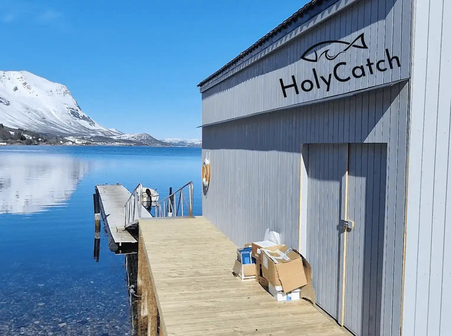 Ein Bootshaus umgeben von Wasser und Bergen